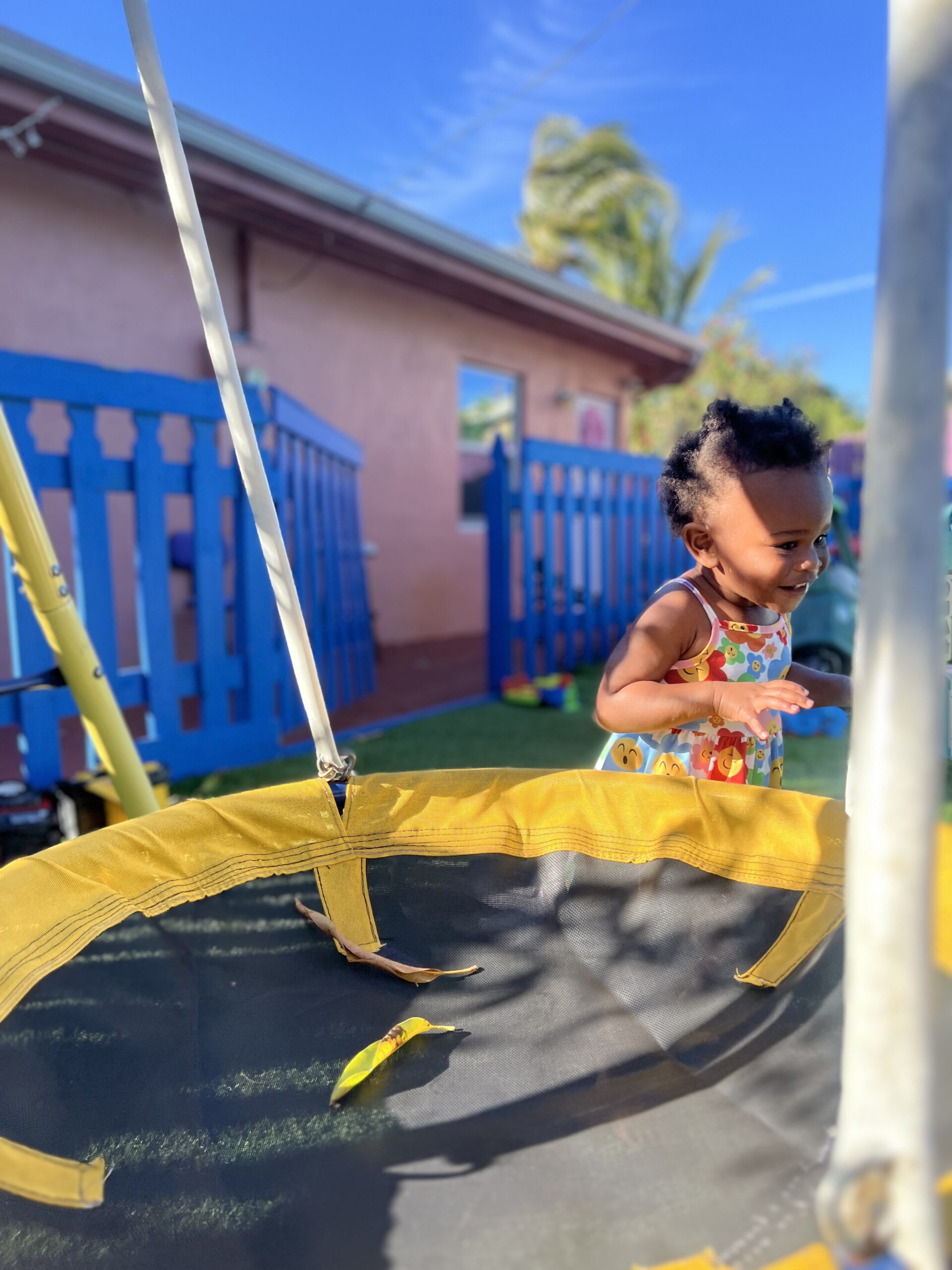 Fenced backyard with bounce house and swings